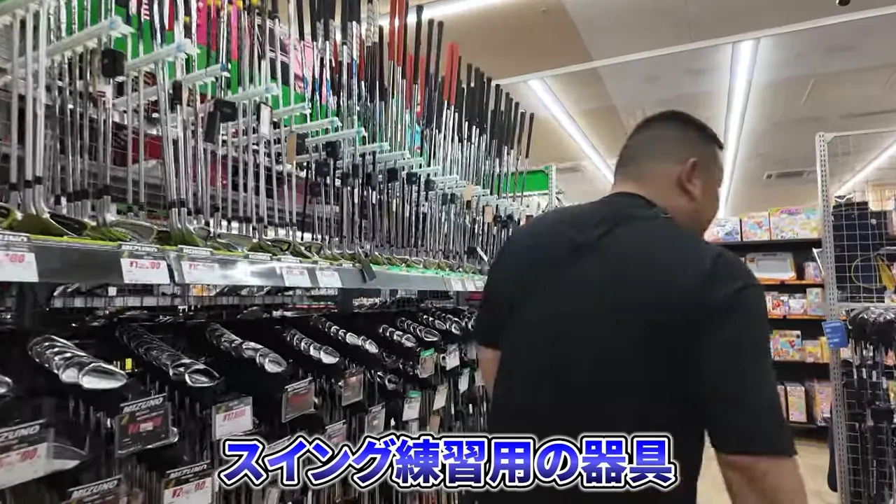 ゴルフコーナーでスイング練習器具を探している様子