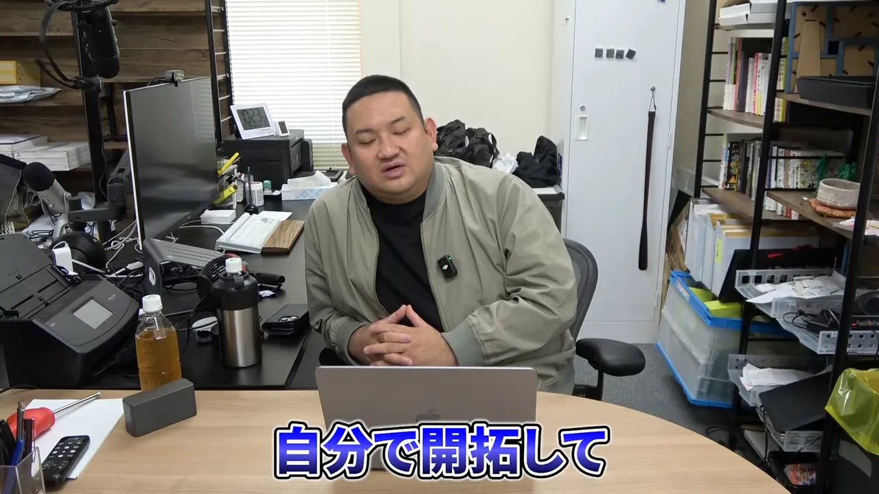 デスクで腕を組み落ち着いて話す人物のクリアなショット