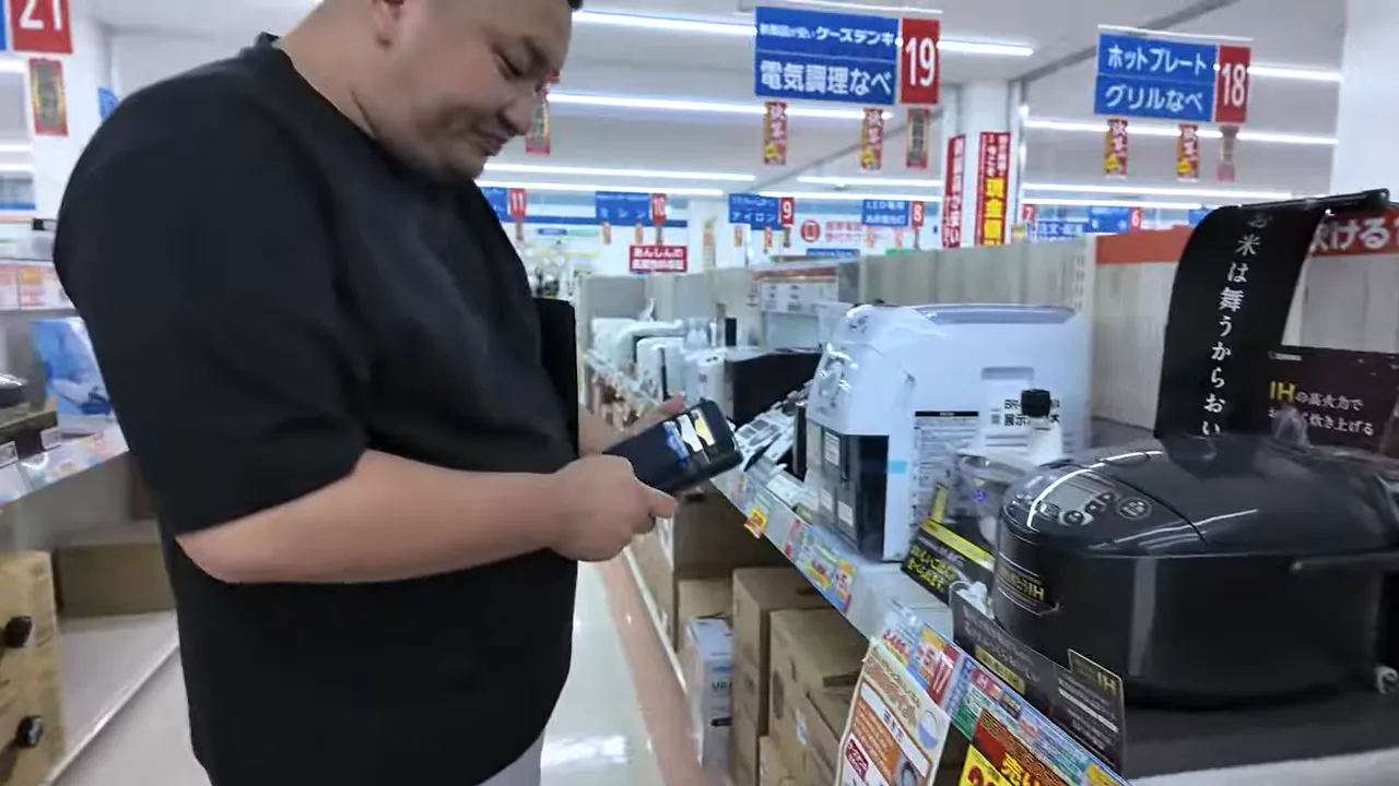 家電量販店の棚で炊飯器をバーコードスキャンする様子