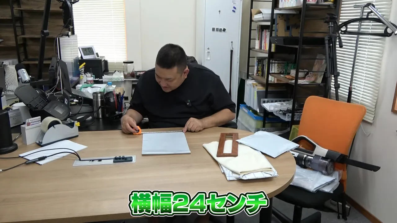 テーブルの上でA4封筒の横幅24センチをメジャーで測る様子