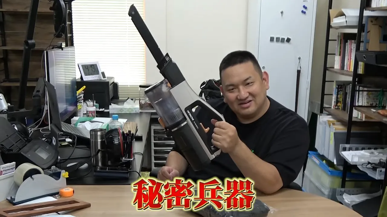 男性がハンディ掃除機を手に持つ様子(圧縮用の秘密兵器)