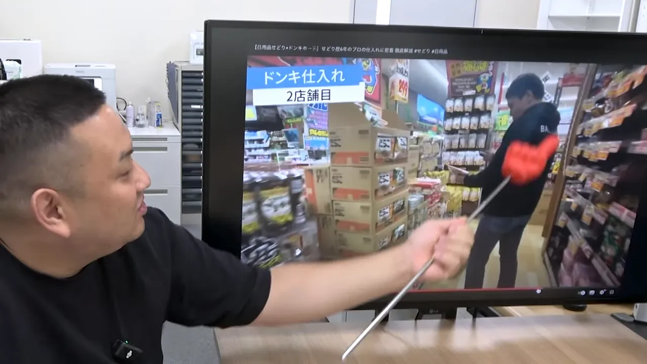 モニターに映るドンキの特売棚と積まれた段ボールを確認する様子