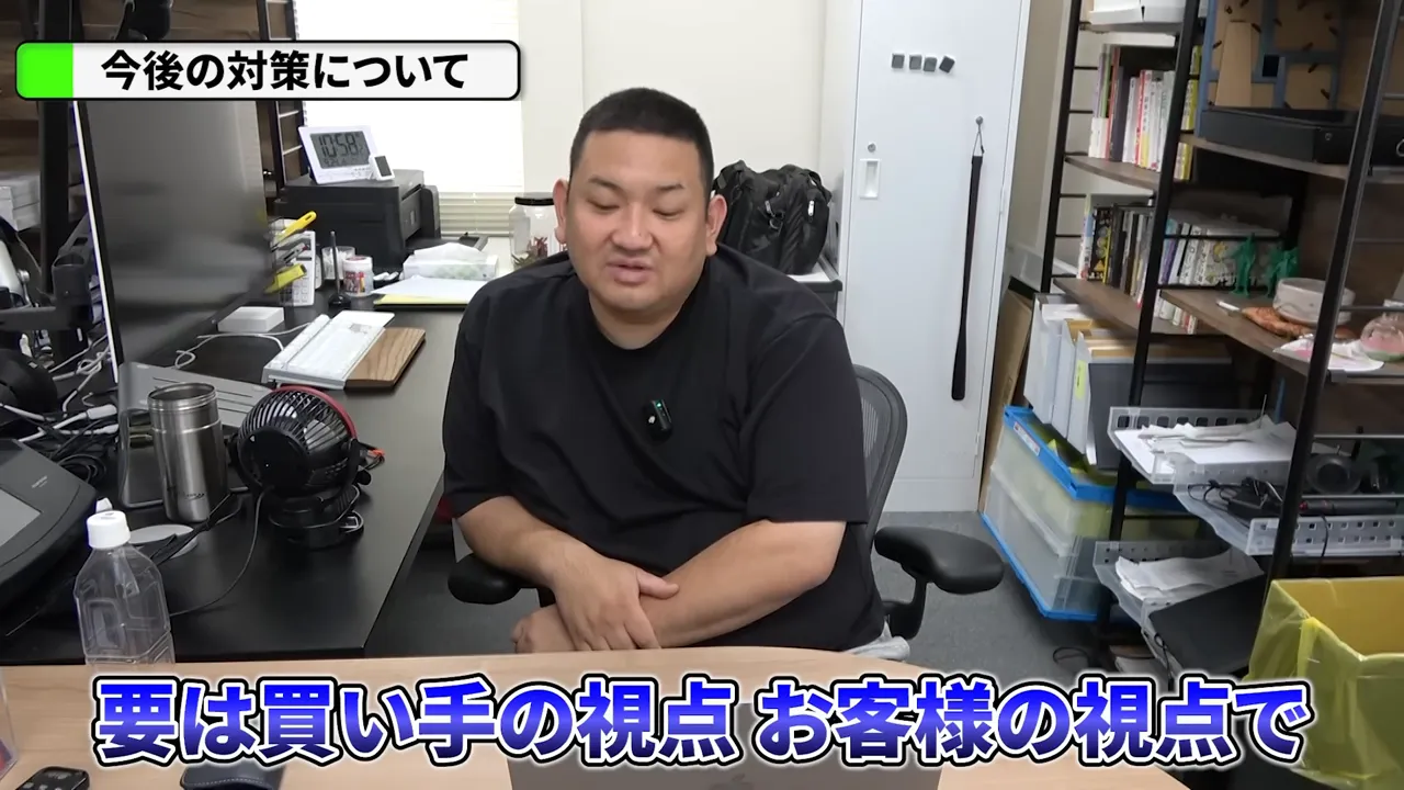 オフィスで説明する人物の中距離ショット、画面下に字幕「要は買い手の視点 お客様の視点で」