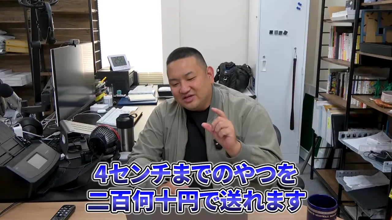 デスクで説明する男性のスクリーンショット。字幕に「4センチまでのやつを二百何十円で送れます」と表示されている