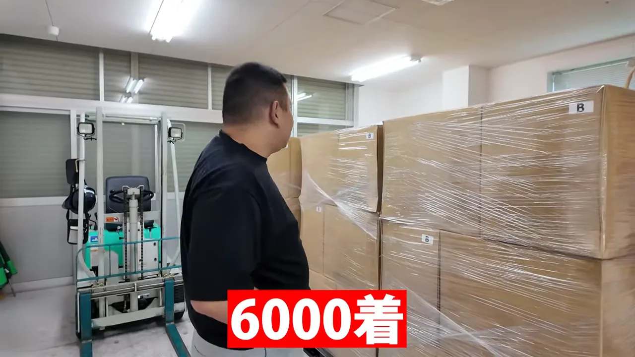 梱包された段ボールが積まれたパレットと大きく表示された「6000着」の文字